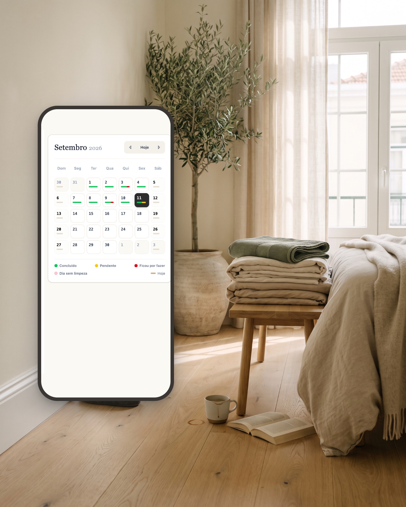 Quarto arrumado com o calendário de setembro da Empregada app no telemóvel, com os dias concluídos